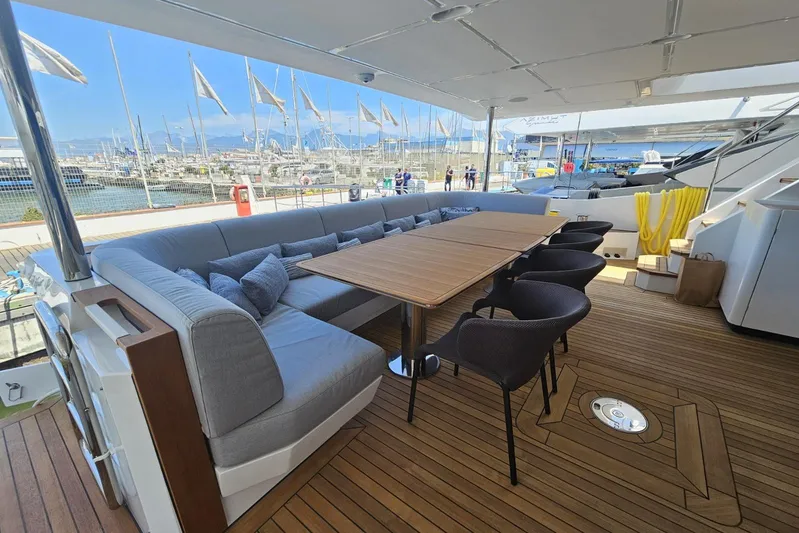 Dream Yacht Photos Pics Luxurious deck seating on 2024 Azimut Grande 32 Metri yacht, featuring elegant wooden table and chairs.
