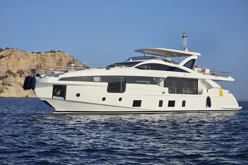 Dream Yacht Photos Pics 2024 Azimut Grande 32 Metri yacht cruising near rocky coastline.