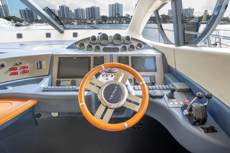 360 Yacht Photos Pics Helm of 2008 Azimut 50 Flybridge yacht with modern controls and city skyline view.