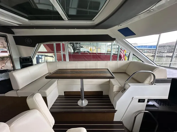 Radical Physics Yacht Photos Pics Interior of 2012 Cruisers Yachts 48 Cantius with elegant seating and wooden table.