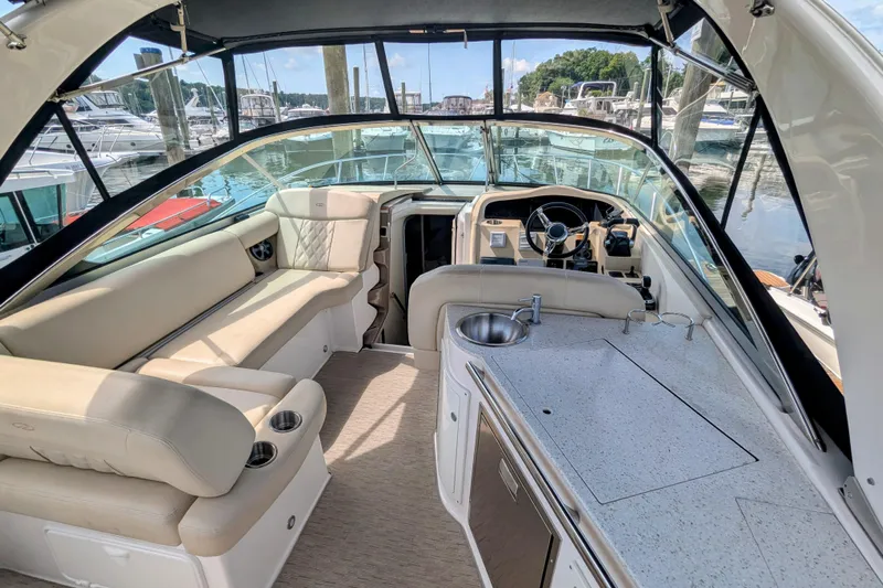  Yacht Photos Pics 2018 Regal 33 XO boat interior with seating, kitchenette, and steering wheel at a marina.