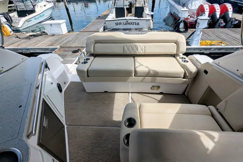  Yacht Photos Pics 2018 Regal 33 XO boat interior with beige seating and cup holders at a marina.