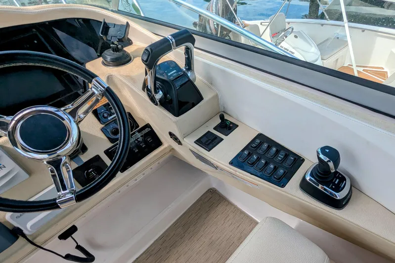  Yacht Photos Pics Cockpit controls of a 2018 Regal 33 XO boat, featuring steering wheel and throttle.