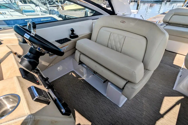  Yacht Photos Pics Captain's seat and helm of 2018 Regal 33 XO boat, featuring luxurious beige upholstery.