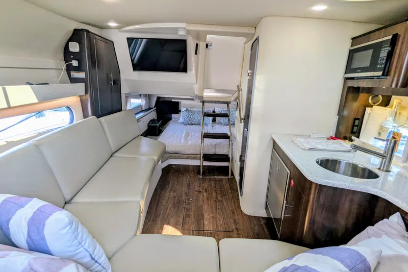  Yacht Photos Pics 2018 Regal 33 XO yacht interior with modern kitchen, seating, and cozy sleeping area.