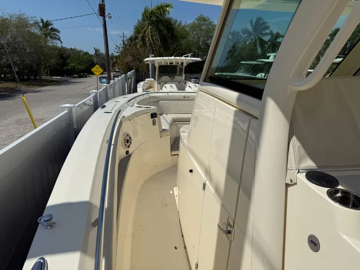  Yacht Photos Pics 2025 Scout 330 LXF boat, sleek design, docked near a tropical road.
