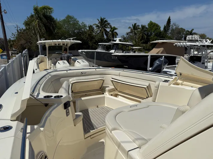  Yacht Photos Pics 2025 Scout 330 LXF boat with spacious seating and sleek design in a marina setting.