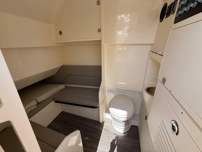  Yacht Photos Pics 2025 Scout 330 LXF cabin interior with seating and compact bathroom.