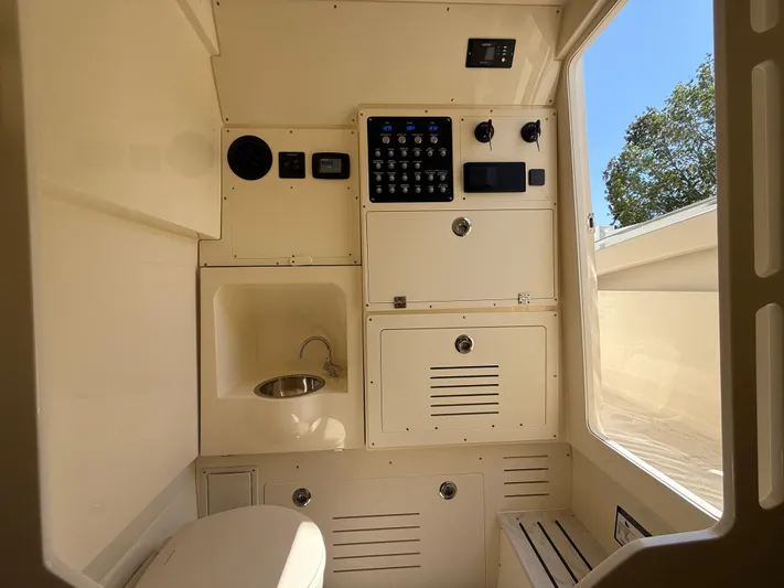  Yacht Photos Pics 2025 Scout 330 LXF boat interior with control panel, sink, and seating.
