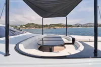 Luxurious 2007 Codecasa 41S yacht deck with seating, table, and canopy, overlooking serene waters.