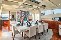 Luxurious dining area on 2007 Codecasa 41S yacht with modern art and elegant table setting.