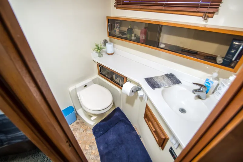 Coda Yacht Photos Pics 1989 Californian 55 Cockpit Motor Yacht bathroom with toilet, sink, and storage shelves.
