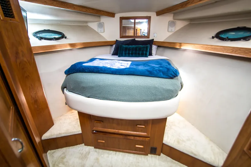 Coda Yacht Photos Pics Luxurious cabin interior of 1989 Californian 55 Cockpit Motor Yacht with cozy bed and wooden accents.