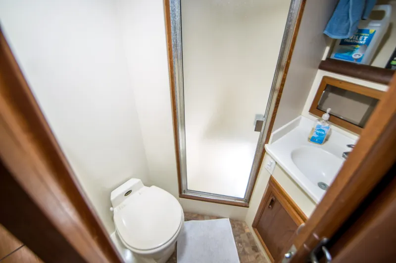 Coda Yacht Photos Pics Bathroom interior of 1989 Californian 55 Cockpit Motor Yacht with shower, toilet, and sink.