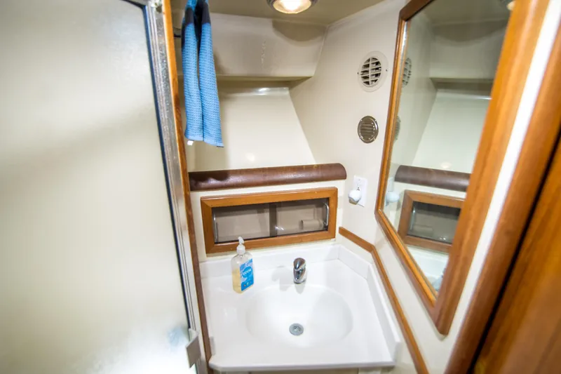 Coda Yacht Photos Pics 1989 Californian 55 Cockpit Motor Yacht bathroom with sink, mirror, and towel.
