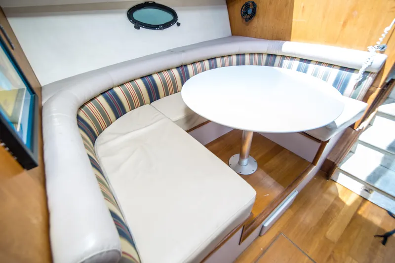 Coda Yacht Photos Pics 1989 Californian 55 Cockpit Motor Yacht interior with striped seating and round table.