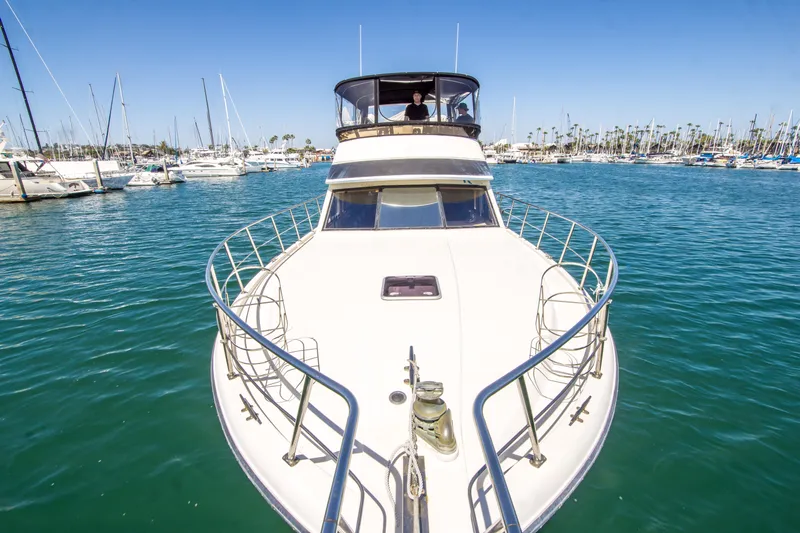 Coda Yacht Photos Pics 1989 Californian 55 Cockpit Motor Yacht on serene marina waters.