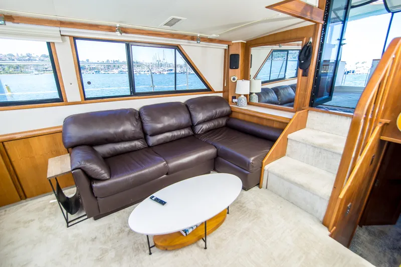 Coda Yacht Photos Pics Luxurious interior of 1989 Californian 55 Cockpit Motor Yacht with leather sofa and scenic windows.