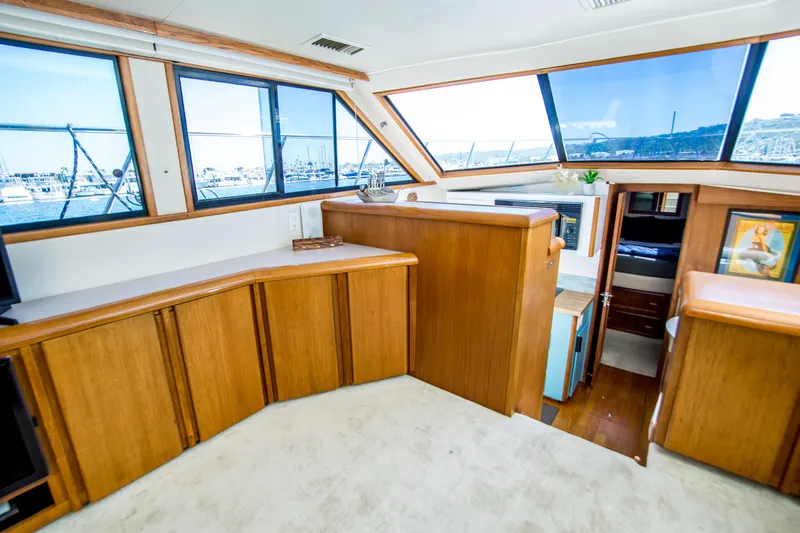 Coda Yacht Photos Pics 1989 Californian 55 Cockpit Motor Yacht interior with wood cabinetry and large windows.