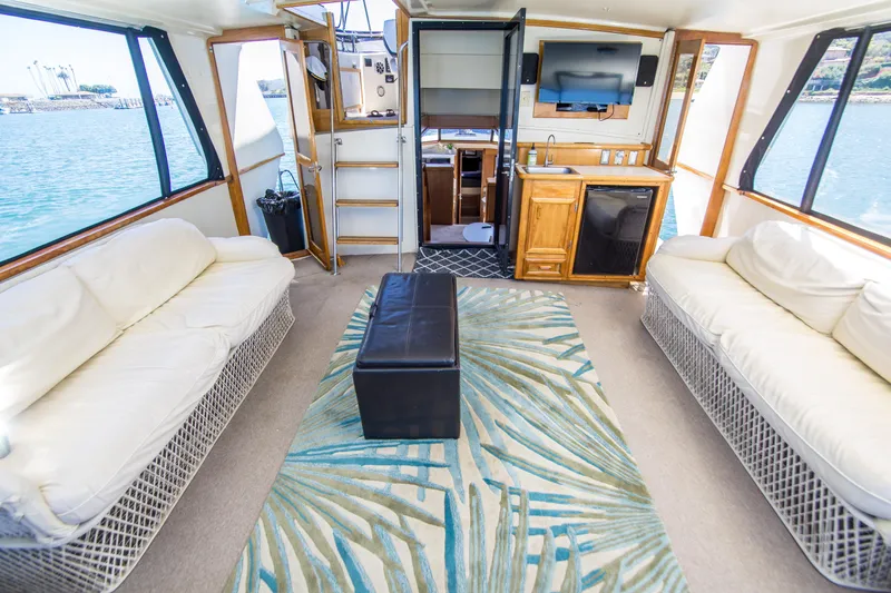 Coda Yacht Photos Pics Interior of 1989 Californian 55 Cockpit Motor Yacht with sofas, TV, and ocean view.