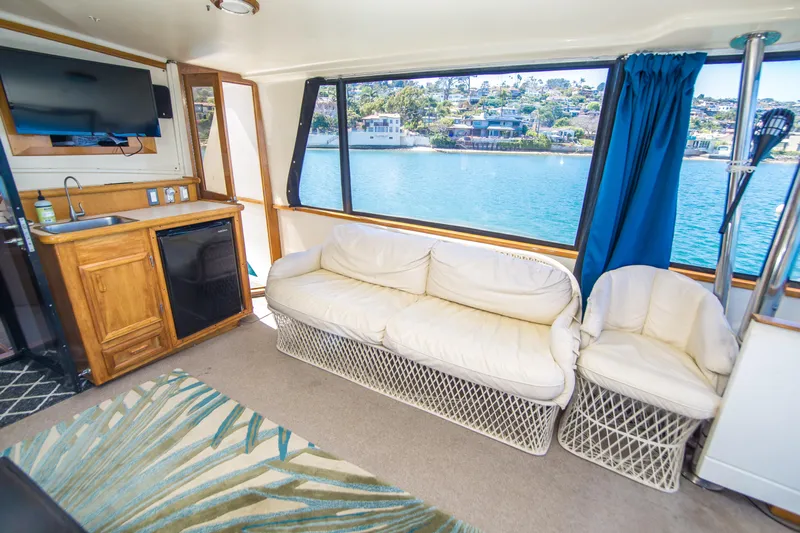 Coda Yacht Photos Pics Interior of 1989 Californian 55 Cockpit Motor Yacht with sofa, kitchenette, and waterfront view.