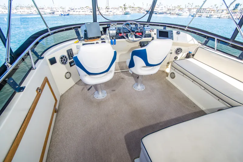Coda Yacht Photos Pics 1989 Californian 55 Cockpit Motor Yacht interior with helm, seating, and panoramic windows.