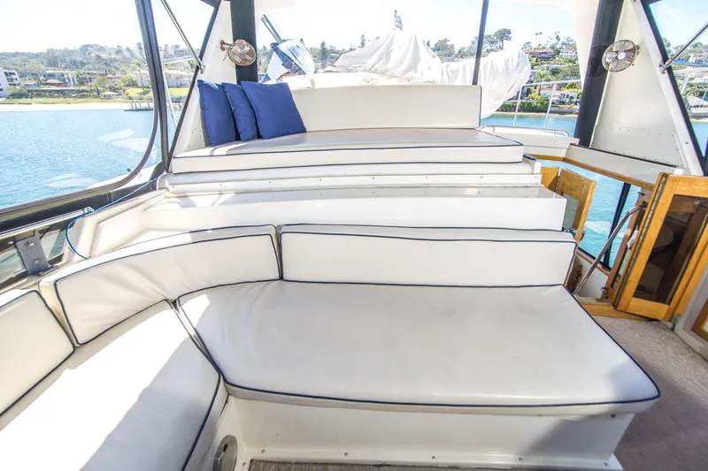 Coda Yacht Photos Pics 1989 Californian 55 Cockpit Motor Yacht interior with white seating and blue cushions.