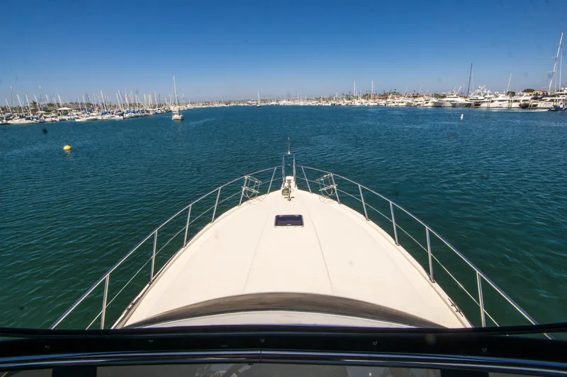 Coda Yacht Photos Pics Bow view of 1989 Californian 55 Cockpit Motor Yacht in a marina.