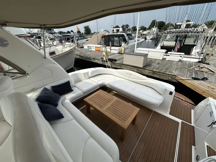 No Tan Lines Yacht Photos Pics 2000 Sea Ray 410 Sundancer yacht with white seating and wooden table at a marina.