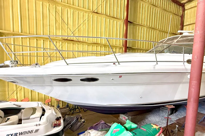No Tan Lines Yacht Photos Pics 2000 Sea Ray 410 Sundancer yacht in storage, side view in a yellow warehouse.