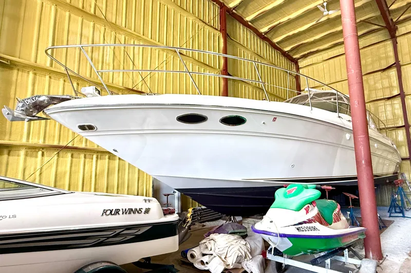 No Tan Lines Yacht Photos Pics 2000 Sea Ray 410 Sundancer yacht stored indoors alongside a jet ski and boat.