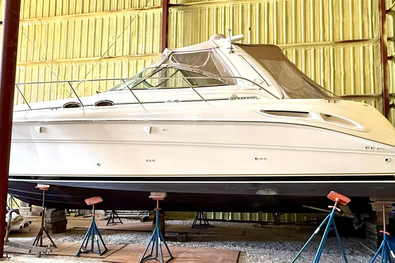 No Tan Lines Yacht Photos Pics 2000 Sea Ray 410 Sundancer yacht in storage, supported by stands in a warehouse.