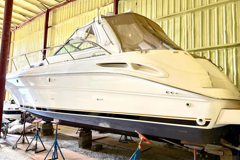 No Tan Lines Yacht Photos Pics 2000 Sea Ray 410 Sundancer yacht in storage, elevated on stands, inside a metal building.