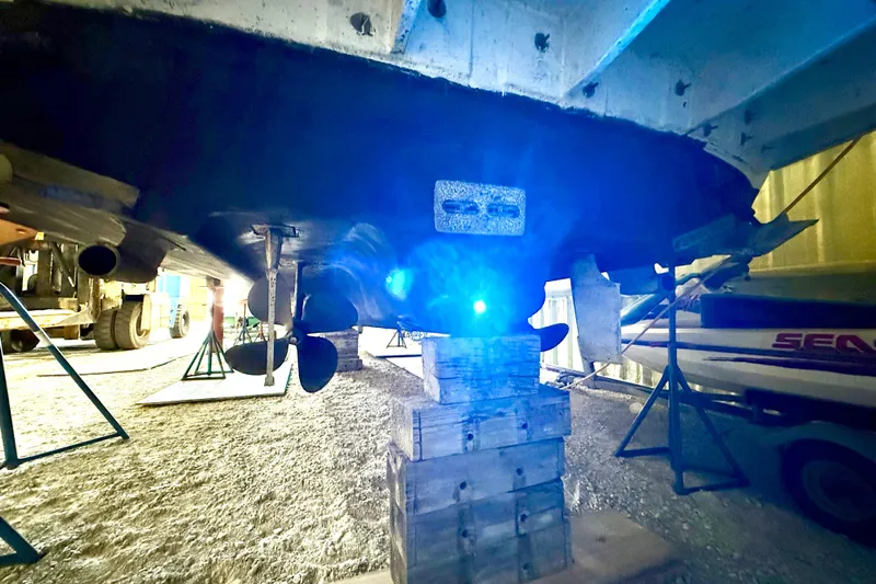 No Tan Lines Yacht Photos Pics Underneath view of a 2000 Sea Ray 410 Sundancer boat on blocks in a workshop.