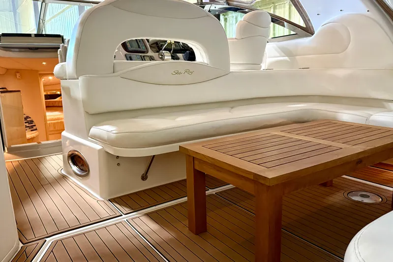 No Tan Lines Yacht Photos Pics Luxurious interior of a 2000 Sea Ray 410 Sundancer yacht with white seating and wooden table.