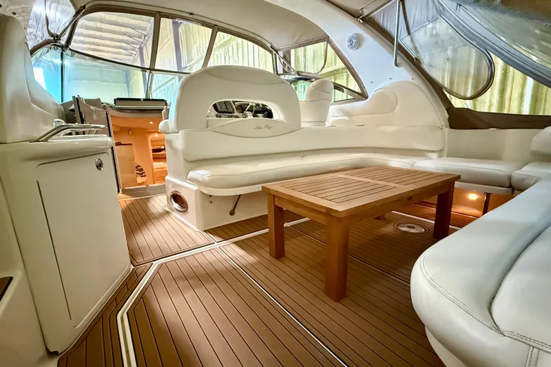 No Tan Lines Yacht Photos Pics Luxurious interior of a 2000 Sea Ray 410 Sundancer yacht with elegant seating and wooden table.