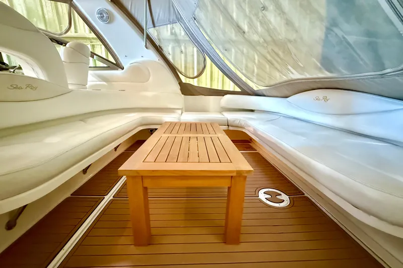 No Tan Lines Yacht Photos Pics Luxurious interior of 2000 Sea Ray 410 Sundancer with wooden table and white seating.