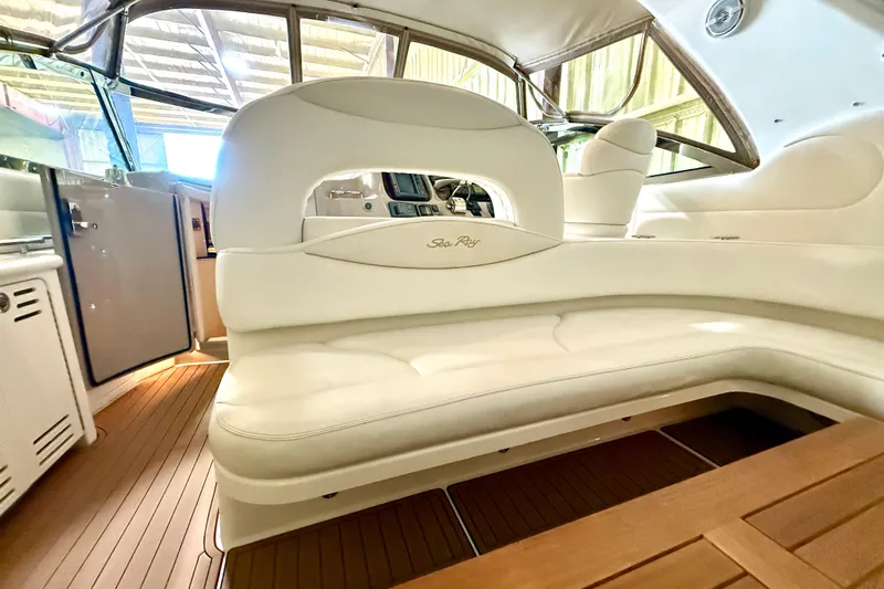 No Tan Lines Yacht Photos Pics Interior of 2000 Sea Ray 410 Sundancer yacht with white seating and wood flooring.