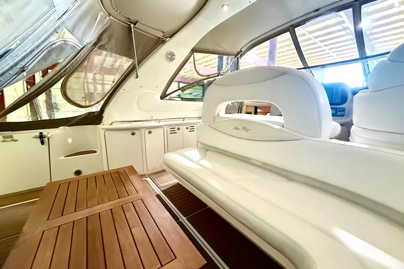 No Tan Lines Yacht Photos Pics Interior of 2000 Sea Ray 410 Sundancer yacht with white seating and wooden table.