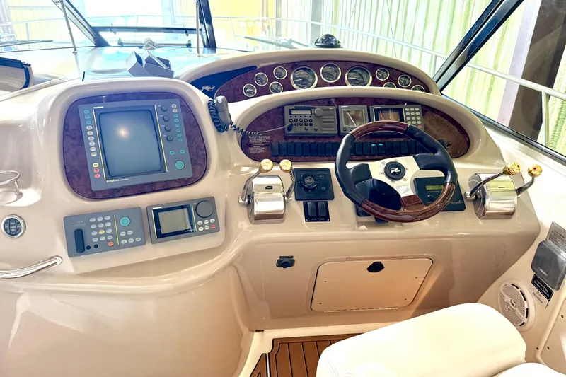 No Tan Lines Yacht Photos Pics Control panel of a 2000 Sea Ray 410 Sundancer yacht, featuring navigation and steering equipment.