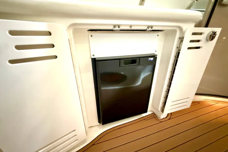 No Tan Lines Yacht Photos Pics Built-in mini fridge on 2000 Sea Ray 410 Sundancer yacht with wooden flooring.
