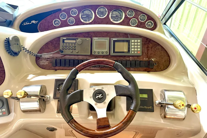 No Tan Lines Yacht Photos Pics Control panel of a 2000 Sea Ray 410 Sundancer boat with steering wheel and gauges.