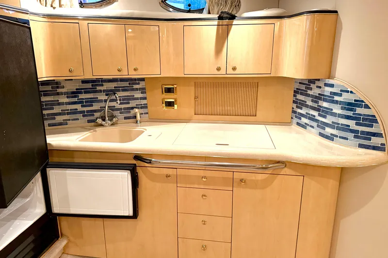 No Tan Lines Yacht Photos Pics Luxurious 2000 Sea Ray 410 Sundancer yacht kitchen with modern cabinetry and blue tile backsplash.