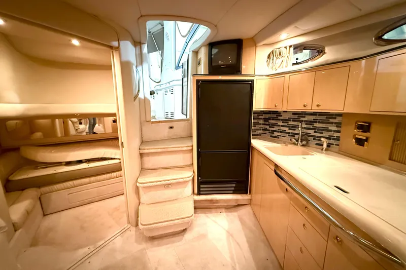 No Tan Lines Yacht Photos Pics Interior of 2000 Sea Ray 410 Sundancer yacht with kitchen and seating area.