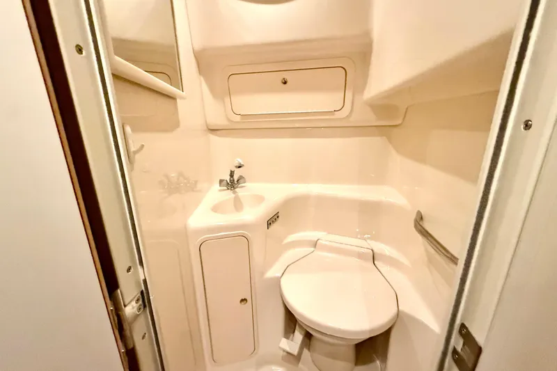 No Tan Lines Yacht Photos Pics Compact bathroom in 2000 Sea Ray 410 Sundancer yacht, featuring toilet and sink.