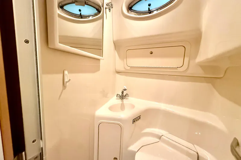 No Tan Lines Yacht Photos Pics Bathroom interior of 2000 Sea Ray 410 Sundancer yacht with sink and porthole window.