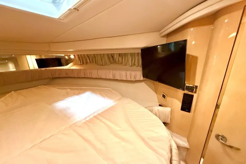 No Tan Lines Yacht Photos Pics Luxurious cabin interior of 2000 Sea Ray 410 Sundancer with TV and cozy bedding.