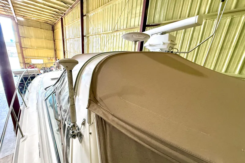 No Tan Lines Yacht Photos Pics 2000 Sea Ray 410 Sundancer yacht in storage, featuring a beige canopy and radar equipment.