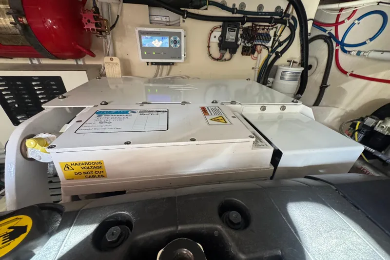  Yacht Photos Pics Engine room of 2016 Tiara Yachts C44 Coupe with electrical components and warning labels.