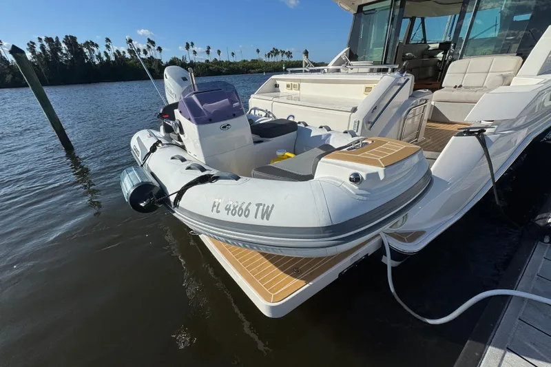  Yacht Photos Pics 2016 Tiara Yachts C44 Coupe docked with inflatable boat on water.